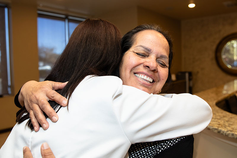 patient and doctor hugging tightly right after patient's dental treatment