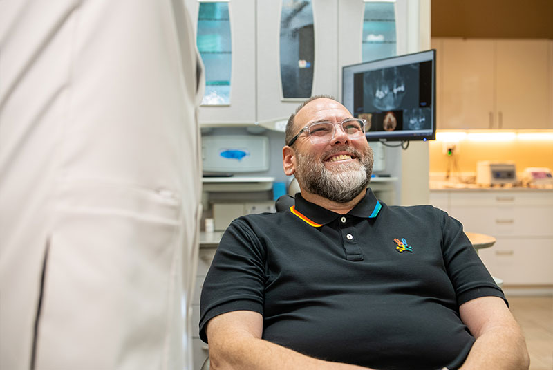 patient smiling and listening to the doctor going over dental procedure
